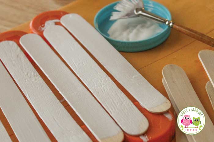 Paint craft sticks to prepare the snowman craft for kids
