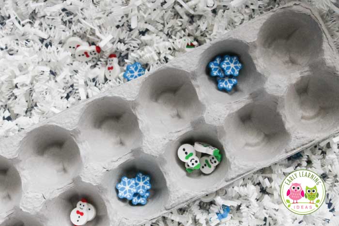 snowflake mini erasers and shredded paper in a winter sensory bin
