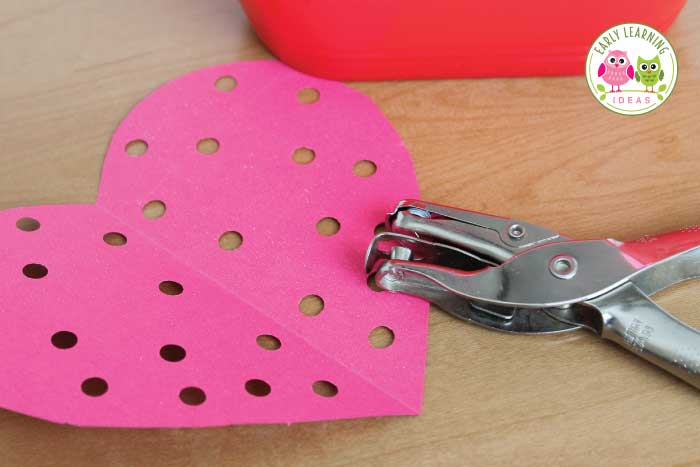 A picture of using a hole punches to create  Valentine's Day Fine Motor Activities for Preschoolers