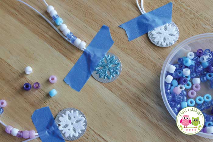 A craft project tip - tape the winter theme necklaces to the table for your kids.