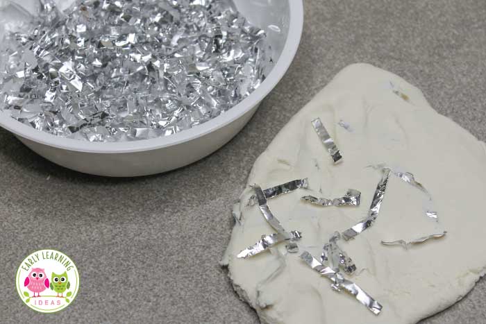 adding shredded foil to white playdough