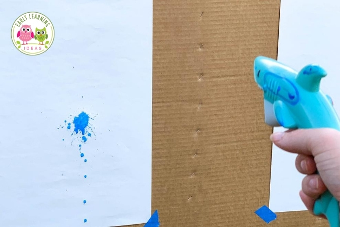 Squirt gun painting is a fun fine motor, hand strengthening, and process art activity for preschool and pre-k. Learn how to do this fun open-ended art project with your kids today. Are you for how to improve hand strength? Squeezing the water gun builds hand strength. This creative art activity is perfect for spring, summer, and fall in school or at home.
