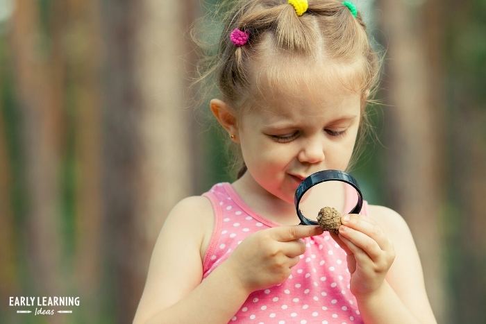 child with magnifying glass - science projects for preschoolers
