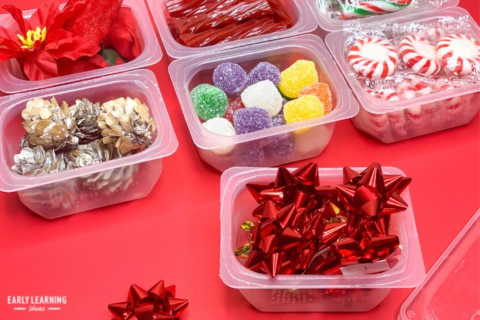 Ideas for supplies and fillers for your Christmas weight activity.   Preparing containers of pine cones, gum drops, peppermint candy, silk poinsettias, and gift bows for containers to use in the preschool Christmas science center