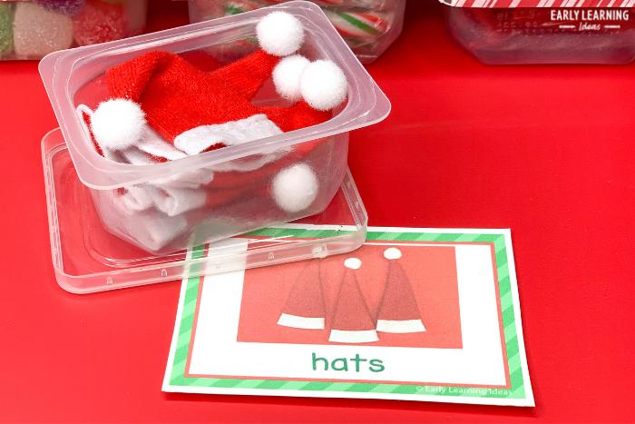 Customized label for a container of Santa hats used in a Christmas preschool science center ideas article about a weight activity 