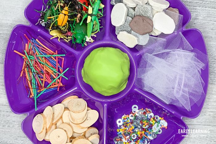 A bug playdough invitation to play with a variety of materials that kids can use to make playdough insects.  The tray is an inexpensive dollar tree school supply for classrooms.
