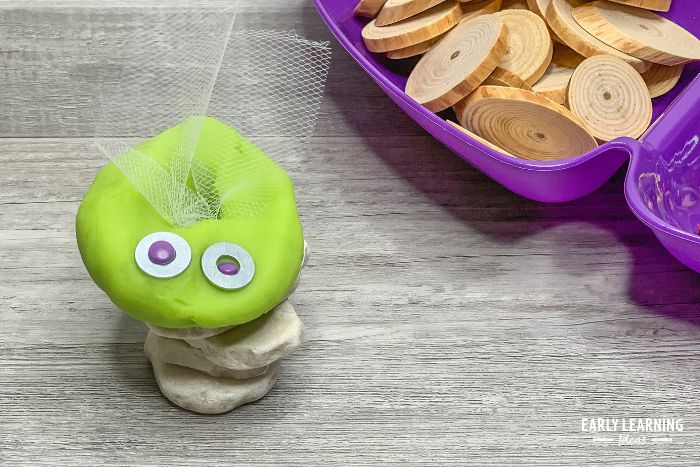 Kids can use a bug playdough tray activity to make playdough insects like this green biug with wings.