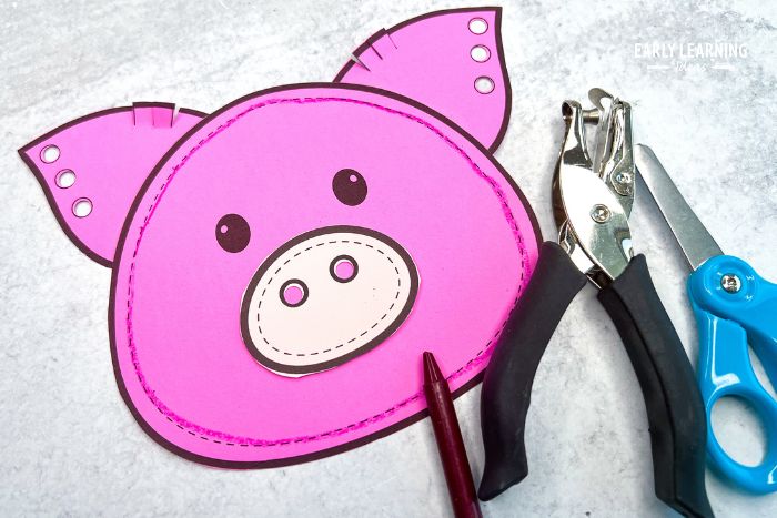printable pink pig craft with a hole punch and scissors - an example of easy farm crafts for prescholers.