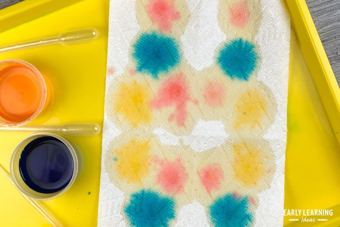 unfolded paper towel with drop of paint on it - an example of fine motor painting activities