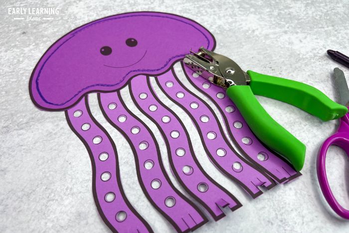 purple jellyfish craft with a green hole punch .  The jellyfish craft template is an example of under the sea crafts and fine motor activities for preschoolers
