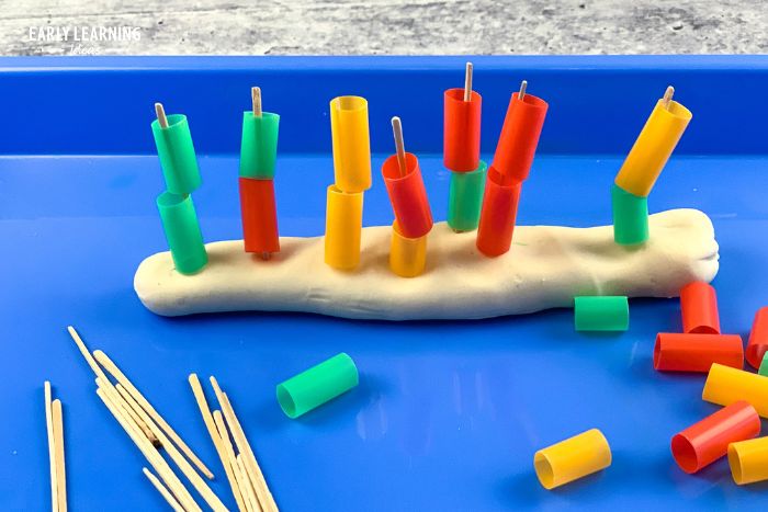 Toothpicks stuck in playdough.  Kids have stacked cut pieces of straws onto the toothpicks.  This is an idea for inexpensive dollar store preschool activities.