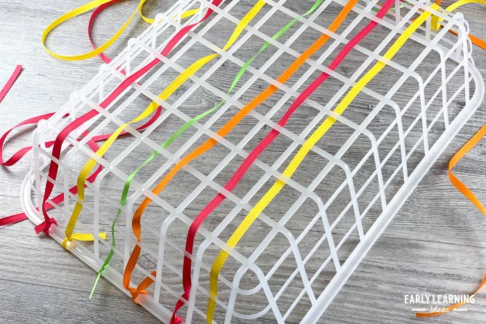 A plastic basket with colorful ribbon woven through it.  This is a fine motor activity and an example of dollar store preschool activities and ideas.