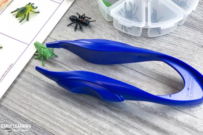 A blue plastic kids tweezer from Dollar Tree with some small plastic bugs. - an example of fine motor dollar store preschool activities and ideas.