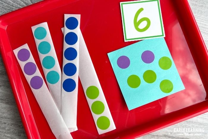 A number card with 6 printed on it.  Purple, teal, blue, and green dot sticker strips and 6 different stickers have been applies to a teal post-it note.  An example of dot sticker activities for kids.