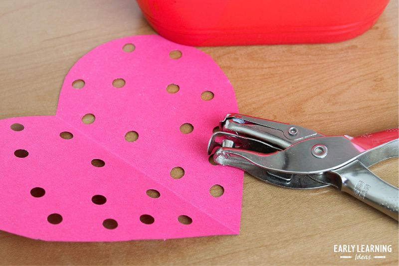 A picture of using a hole punches to create  Valentine's Day Fine Motor Activities for Preschoolers