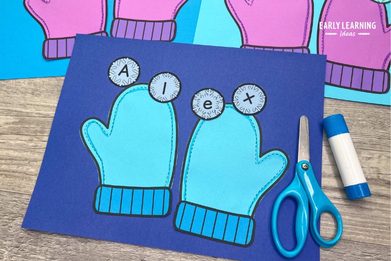 winter crafts for preschool - mittens name craft. The cut and paste craft is shown pasted to blue construction paper.