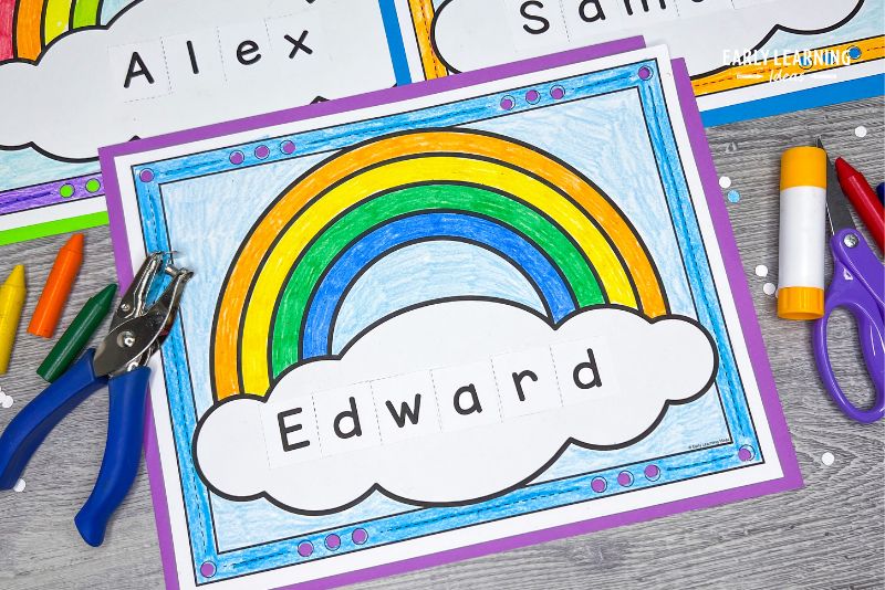 A rainbow name craft with the name Edward in the cloud. It is shown with a hole punch, crayons, a glue stick and scissors and is an example of St Patricks Day crafts for preschool kids