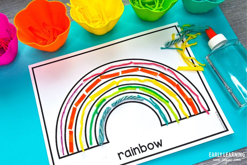 A rainbow craft made with yarn collage. Different colors of yarn are glued onto a rainbow printable