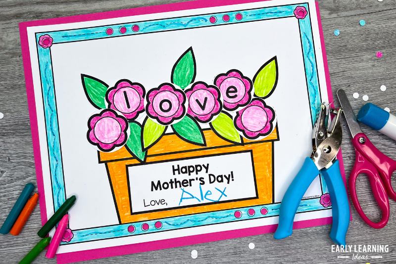 Printable cut and paste Mother's Day craft. The word "love" is spelled in the flowers and a label that reads "Happy Mother's Day" has been added to the flowerpot.