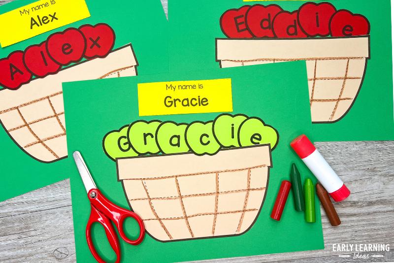 paper apple basket name craft for preschool or kindergarten. The name Eddie is spelled with green apples and shown with scissors, crayons, and glue stick