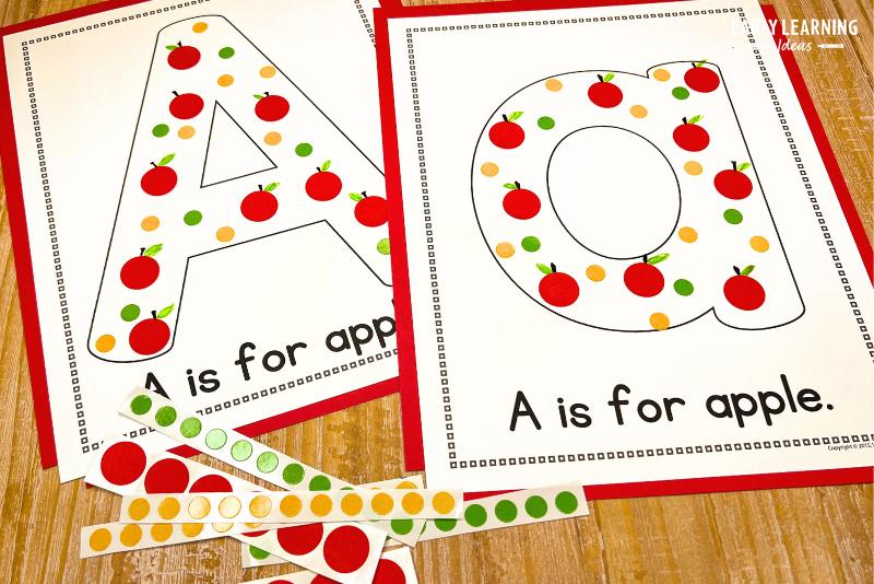 A is for apple craft - The letter a craft is printed on white paper and red, yellow and green stickers are added to the bubble letters. Stems and leaves are added with markers to some of the dot stickers to create apples