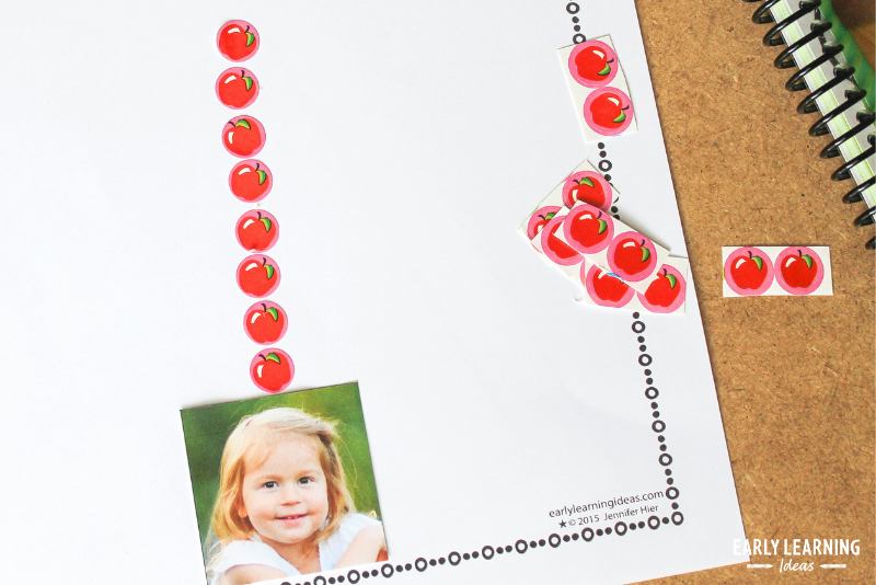 a page from an apples on top counting book. A child's image has a number of apples pasted above her head.