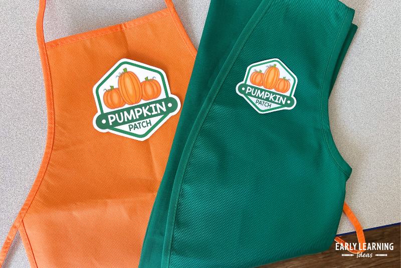 apron and vest with a pumpkin patch logo used for dress up clothes in a pumpkin patch and bakery dramatic play center