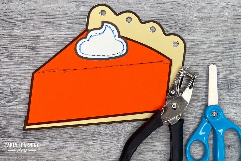 pumpkin pie paper craft for preschool and kindergarten shown with holepunch and scissors