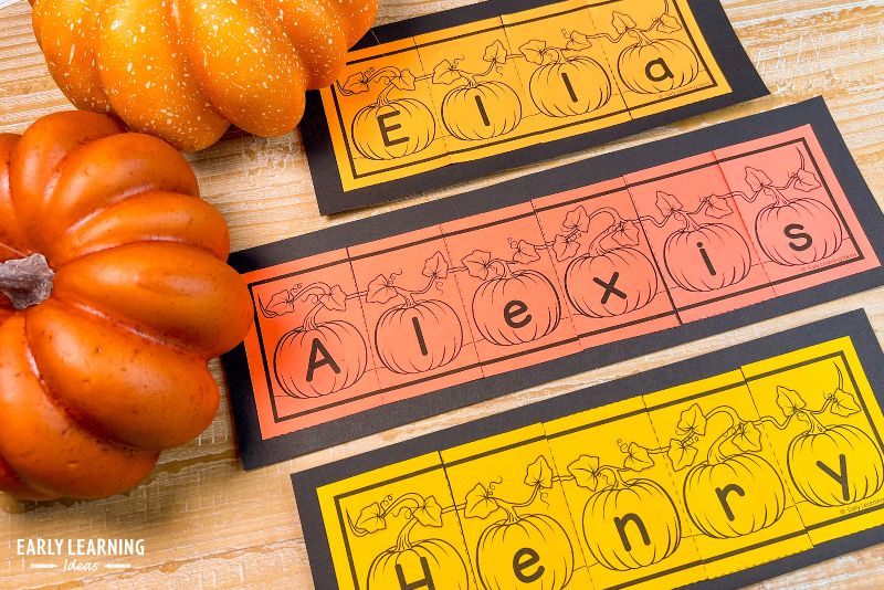 pumpkin name craft and puzzle pasted on a black construction paper background shown with a pumpkin