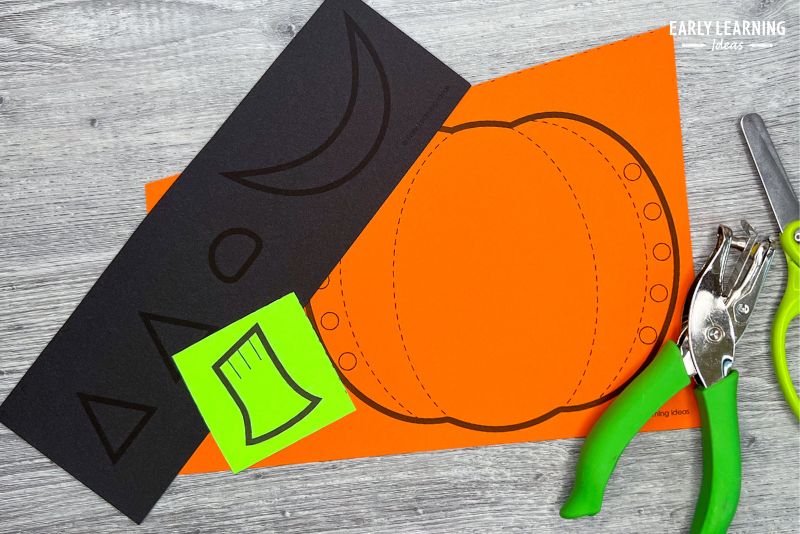 pumpkin paper craft shown with scissors and holepunch