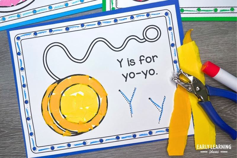 Y is for yo-yo craft shown with torn paper and a hole punch