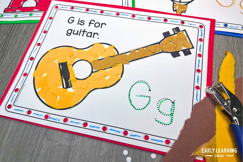 G is for guitar letter g craft shown with a hole punch and torn paper