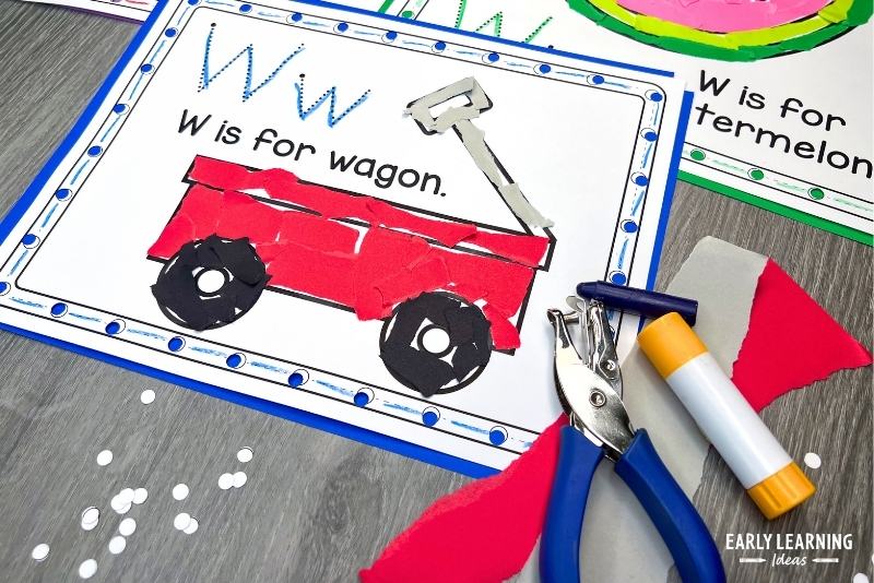 W is for wagon craft for preschool kids shown with torn paper, glue stick, and hole punch