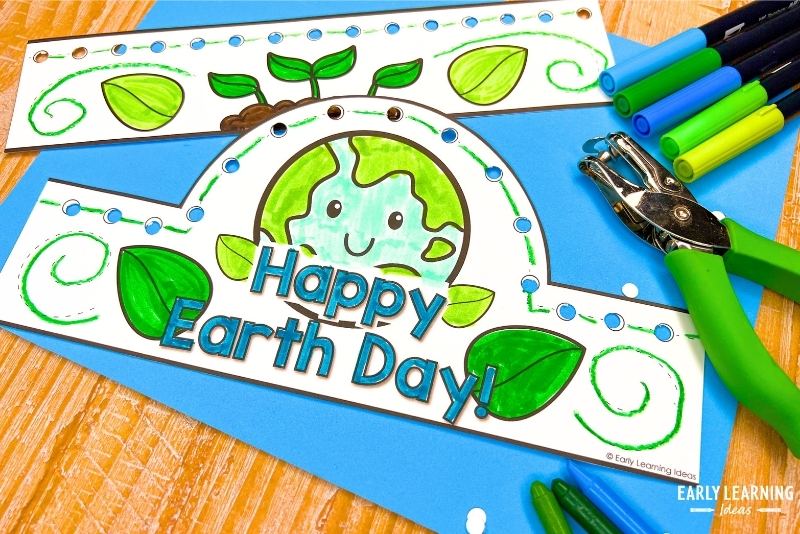 Earth Day headband crown craft shown with markers and a hole punch