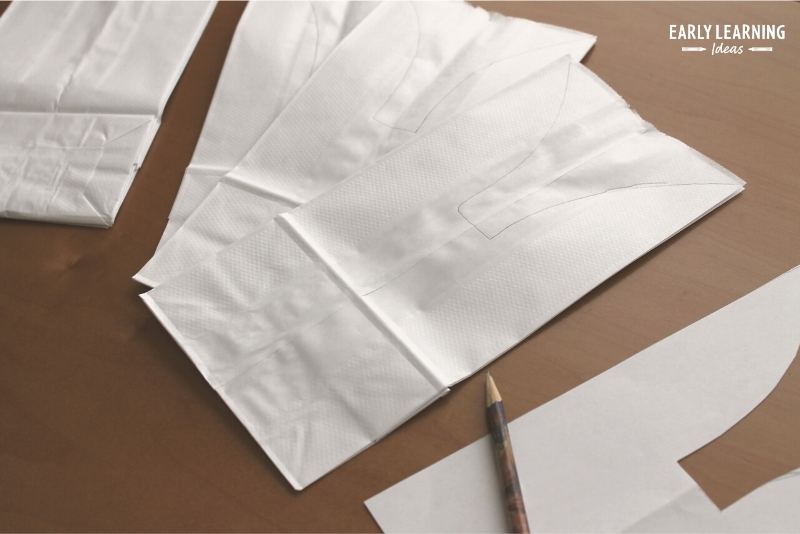 How to make Easter bunny craft. Use the printable pattern to trace the bunny's ears onto the white paper bag.