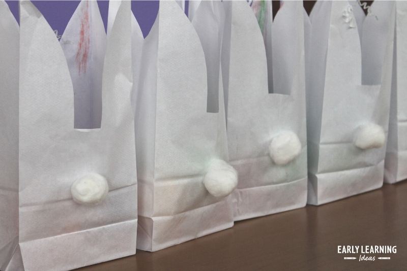 paper bag Easter bunny craft for preschoolers with cotton ball tails on the back of the bag