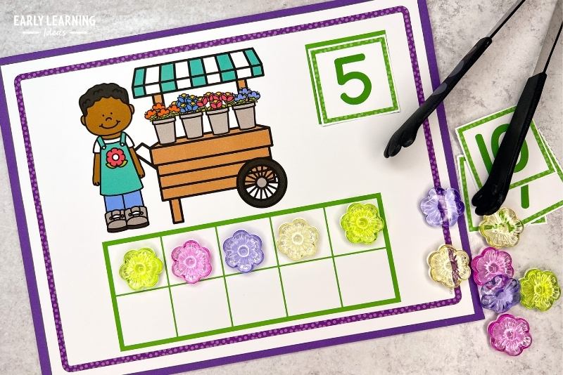 flower fine motor activities for preschoolers - a flower math mat with a number 5 card, 5 plastic flowers, and tongs