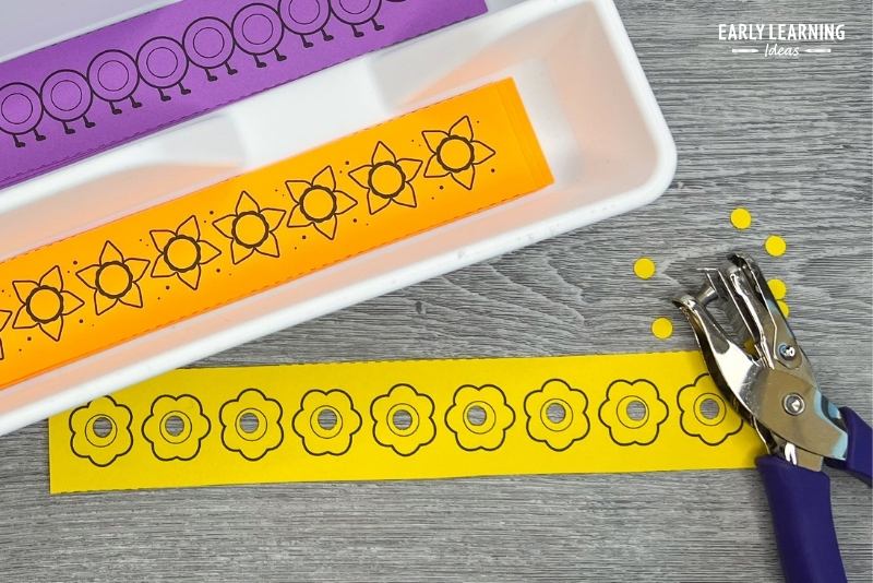 A small dot sticker strip with flowers on it.  Shown with a hole punch and used as a hole punch strip.
