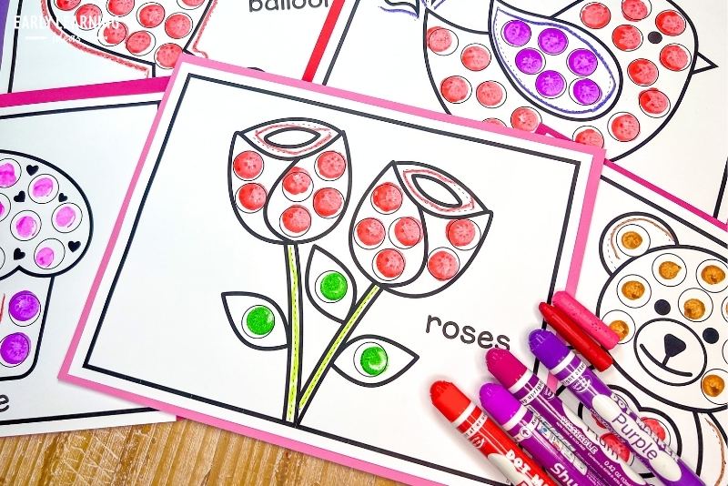 Rose dot marker coloring sheet shown with bingo daubers and crayons