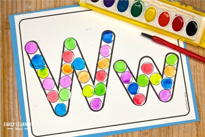 Letter w alphabet dot letter page printable on white paper, shown with watercolor paint. The dots inside the bubble letters are painted with bright watercolor paint.