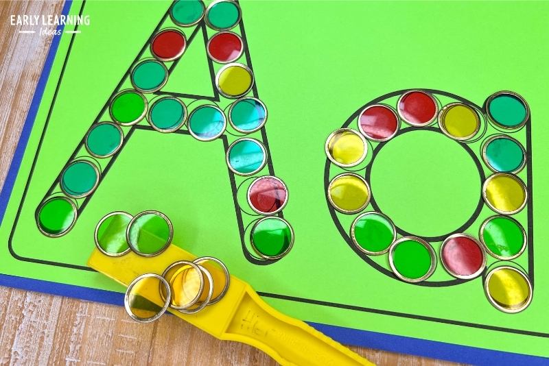 A letter a alphabet dot page is shown with magnetic chips and a magnet wand.