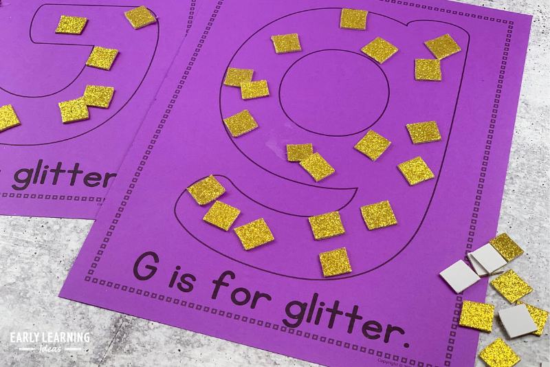 letter G is for glitter alphabet activity.  Pieces of glittery foam are stuck to the letter g on the page.